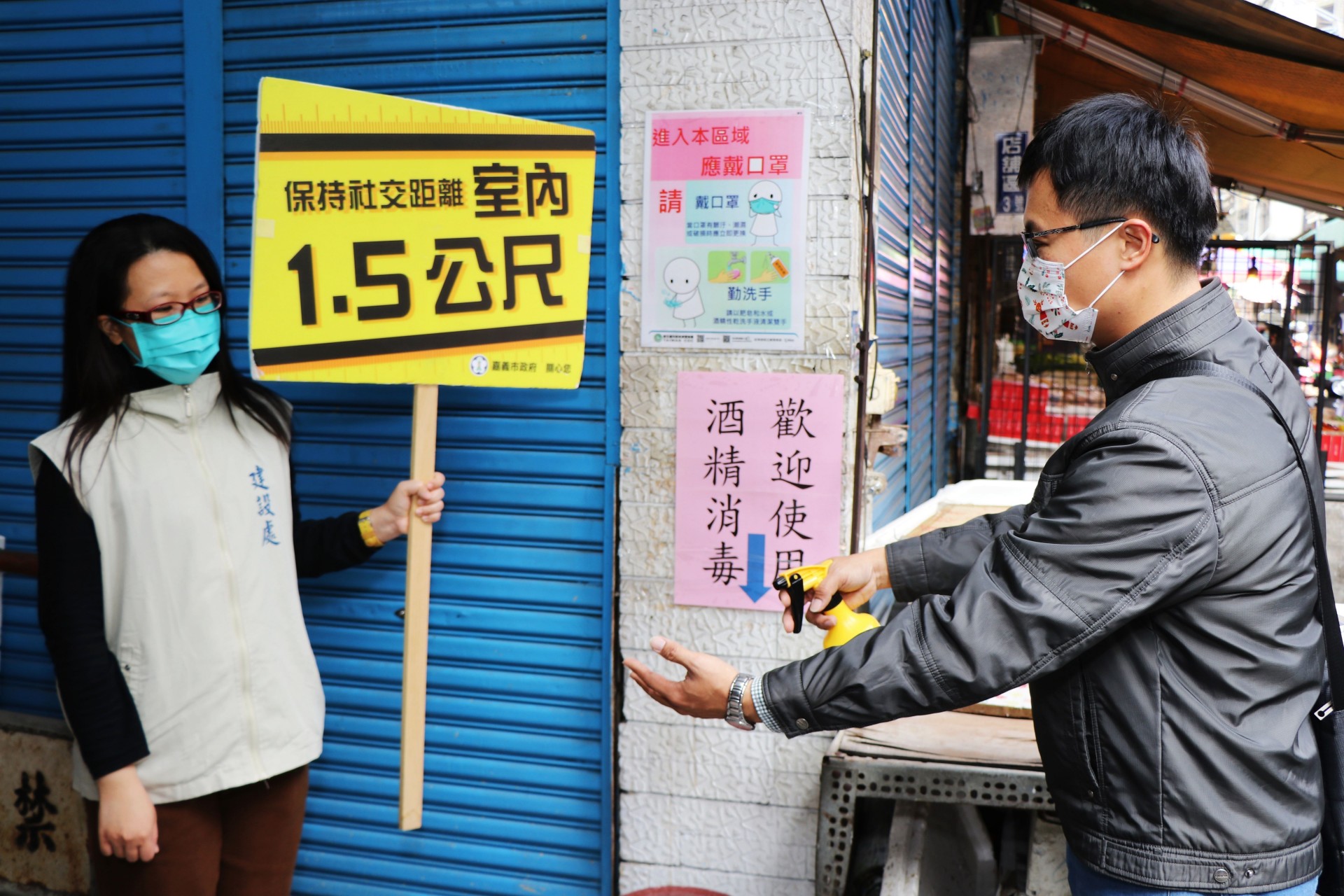 0_手持立牌，提醒民眾保持室外1公尺、室內1.5公尺的社交安全距離，噴酒精。.JPG